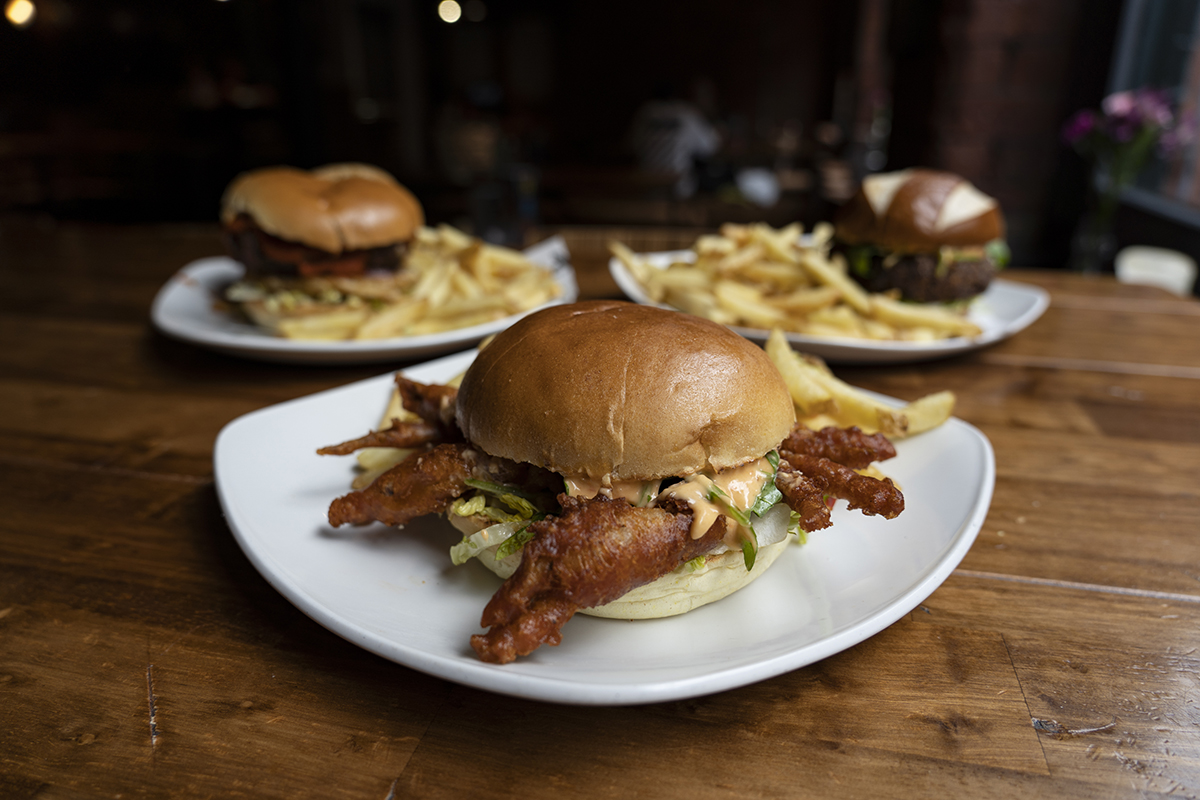 Selection of three burgers including a soft shell crab burger at the forefront